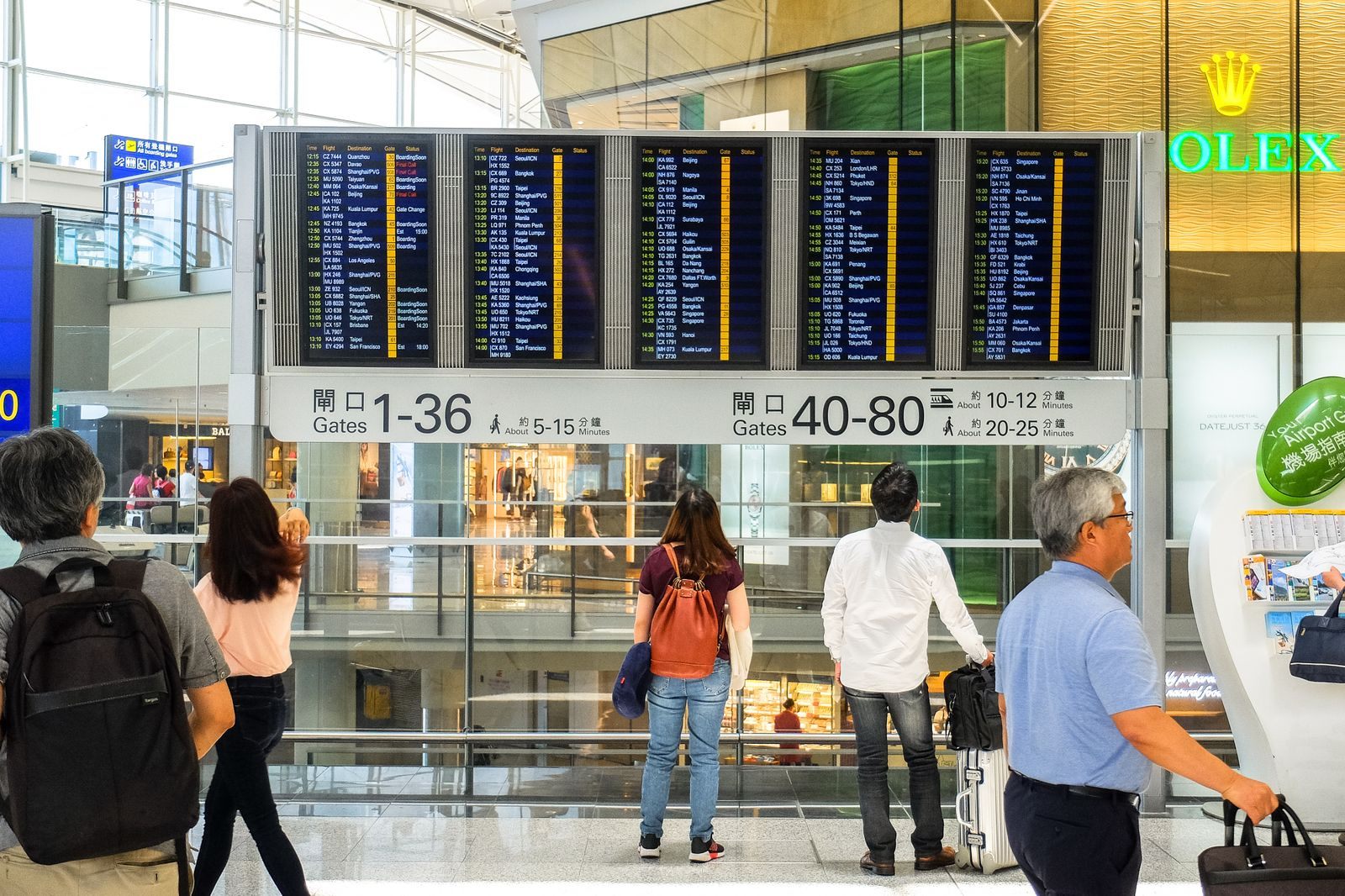 Travelers at airport departure screens